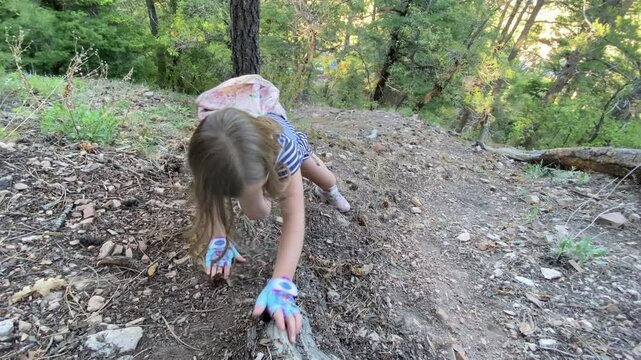 Young Girl Climbing Down a Steep Mountain