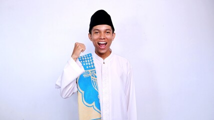 excited handsome young asian muslim man gestures raising his hand with isolated white background