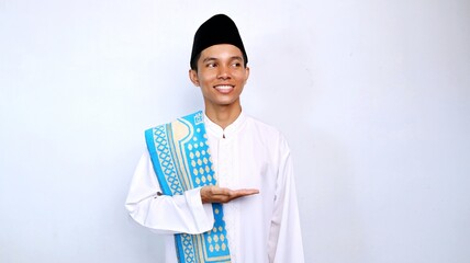 handsome asian muslim young man excited pose showing open palms and looking sideways for promotion, product and discount. recommend something with isolated white background