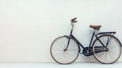 Vintage bicycle leans against white wall, outdoor background