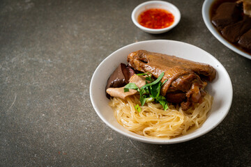 dried noodles with braised duck in white bowl