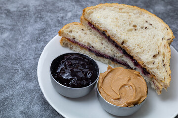 Peanut butter and jelly sandwich on a white plate. With copy space.