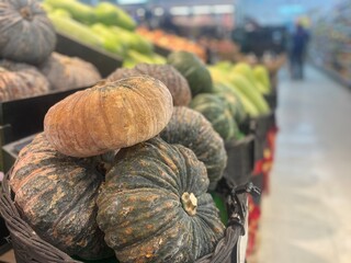 Fresh Pumpkins on Display with Blurred Vegetable Background in a Market
