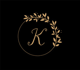 The logo has an elegant and classic design, with the main element being a monogram of the initials, such as the letters A and B, written using a calligraphy or serif font with fine details. The gold c
