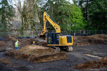 New home construction foundation earthwork, surveyor with laser level range finder, heavy equipment...