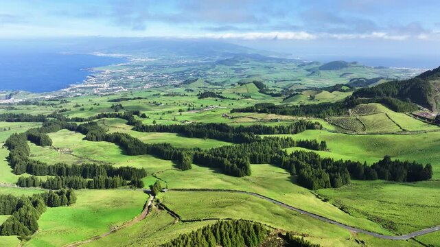 Wide drone view over lush S&atilde;o Miguel landscape and Pau Pique lake, Azores