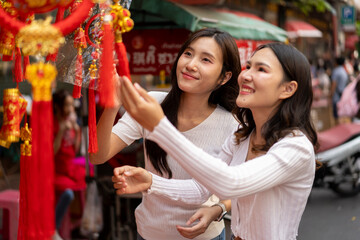 Young Asian Women Shopping for beautiful red ornament Offerings Outdoors market