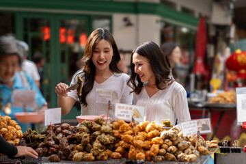 Two Women Enjoying Street Food at a Bustling Market in urban