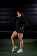 Fototapeta premium Sporty woman posing in a dark gym after training