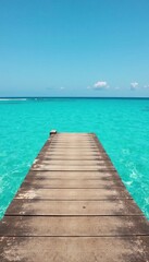 Obraz premium Weathered wooden plank extends over turquoise sea, texture, photography, view