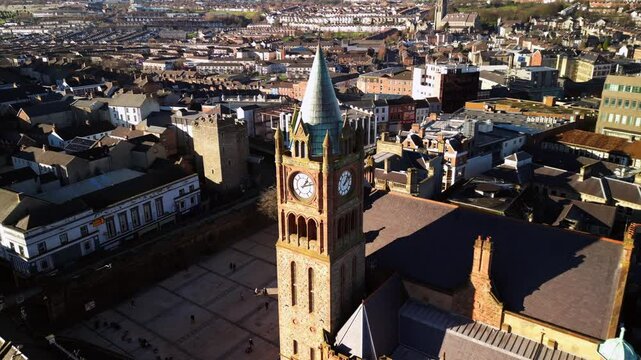 Aerial shot of the Guildhall Clock in Derry-Londonderry on a bright and sunny day. The camera begins close-up on the clock face and travels backwards. Filmed in 4K, 30fps and with Rec709 color.