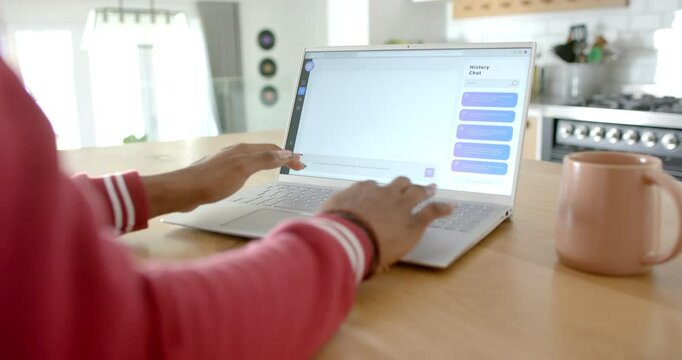 African American woman typing on laptop, showing Ai Chat Bot Screen, at home