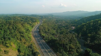 Aerial View of a Highway Winding Through Lush Green Mountains