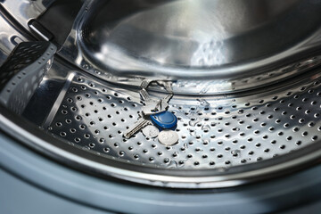 Close-up a metal objects in the washing machine that damage the washing machine if left in pockets.
