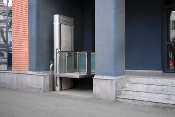 Modern electric lift ramp for wheelchair users at the entrance.