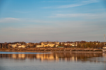 Obraz premium Aerial view of a small provincial town on the banks of the river at sunset.