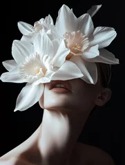  Woman with narcis flowers on her face against a black background. © Studio F.
