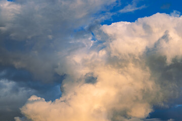 A few light cumulus and cirrus clouds in a clear blue sky, depicting a bright summer day