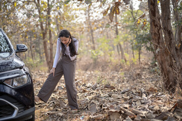 Fototapeta premium A frustrated girl near her damaged or punctured car