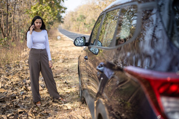 Closeup portrait young frustrated upset annoyed woman near her broken car calling for help on cell