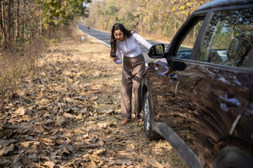 Fototapeta premium Closeup portrait young frustrated upset annoyed woman near her broken car calling for help on cell