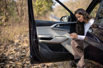 young woman driving in car and checking her phone network, annoyed by navigation gps system or bad...