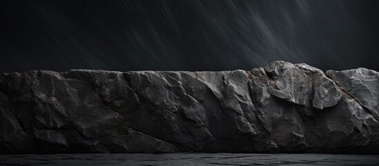 Textured black stone background with pronounced shadows and subtle variations in gray tones, ideal for overlaying images or text.