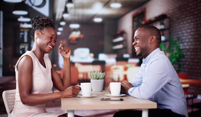 Laughing Male And Female Sitting In Cafe Drinking Coffee