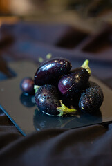 Raw fresh striped eggplants, dark background, rustic style, selective focus, low key