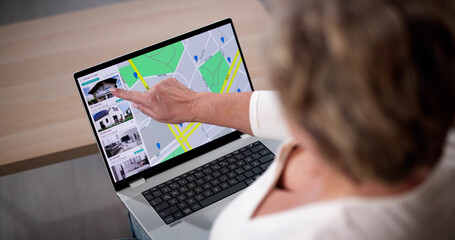 Woman Using Laptop To Search Online Real Estate Property Listings