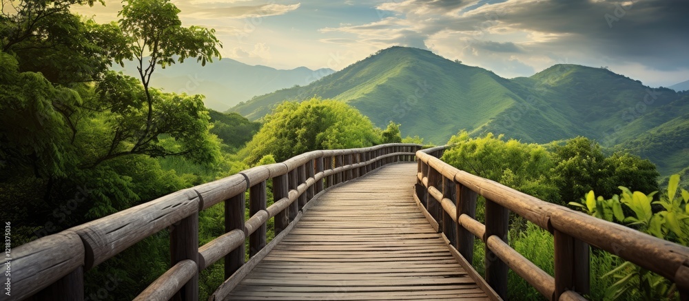 Poster serene wooden walkway through lush green hills under a soft cloudy sky with distant mountains in the