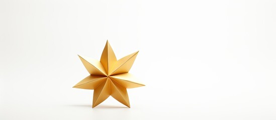 Obraz premium Golden origami star in metallic yellow positioned off-center on a clean white background highlighting shadows and shape details for a minimalist look.