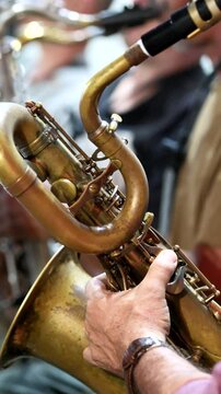 hands playing musical instrument baritone saxophone, selective focus, detail shot, hands only