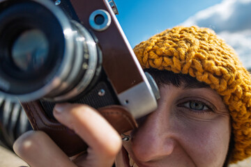 Obraz premium young girl with a camera. photographer with camera. Stylish girl with a film camera. takes a shot.