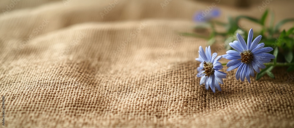 Canvas Prints Natural linen fabric with a distinct weave pattern in warm beige tones, featuring delicate blue flowers positioned in the bottom right corner.