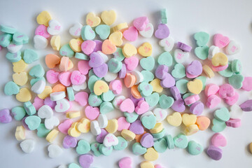 Looking down conversation candy hearts, white bowl, pink background