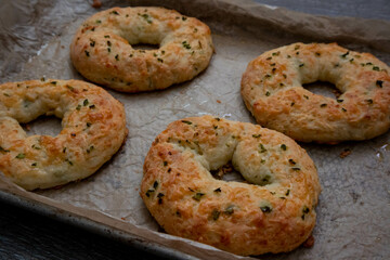 Close-up baked four homemade jalapeno cheese bagels, parchment paper.