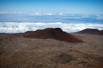 Red volcanic landscape above clouds on Mauna Kea Hawaii