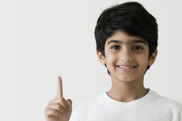 Smiling Child Pointing Upward with One Finger in Gesture of Idea or Alertness