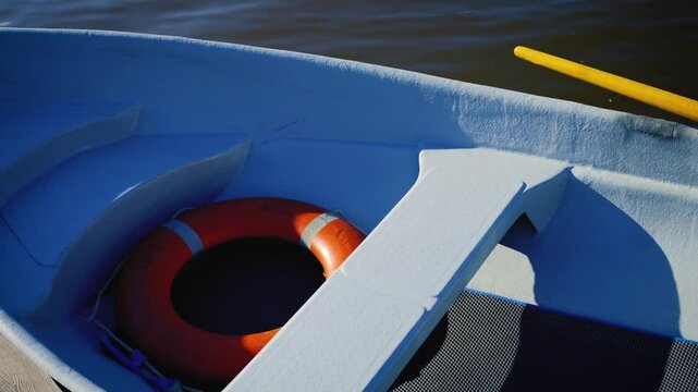 A boat on the water with a lifebuoy. A sunny windless day.