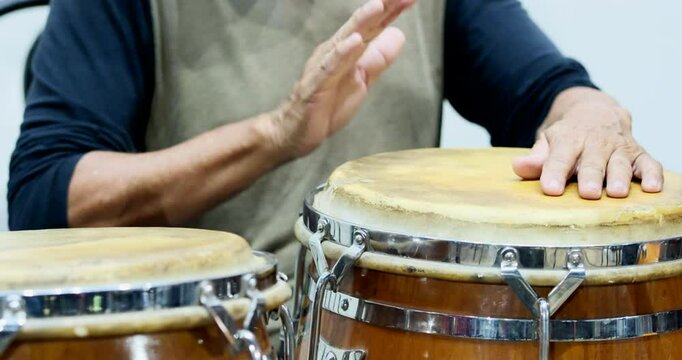 hands playing percussion musical instrument congas, selective focus, detail shot, hands only