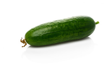 Vibrant cucumber resting on a clean white surface illuminated by soft light in a kitchen setting