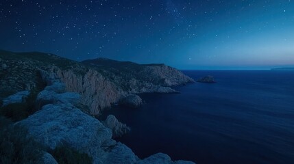 Starry night sky over a dramatic coastline.