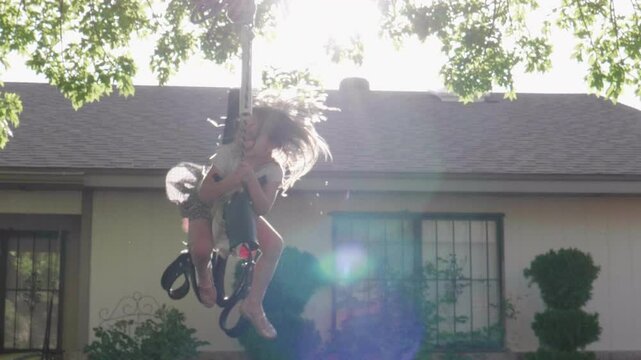 Happy Little Girl Happily Swinging in Horse Swing