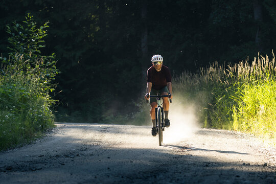 Gravel biker riding a quiet forest path, capturing adventure.