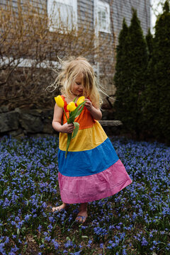 Young girl holding tulips standing in flowers