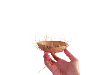 Hands holding a bowl made of coconut shell.