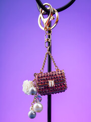 close up of beautiful shiny pink  rhinestone handbag keychain on  purple background