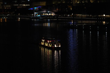 Fototapeta premium Experience the Singapore River Sightseeing Cruise, gliding past colonial buildings, modern towers, and iconic landmarks—offering scenic views of the city’s vibrant waterfront. 
