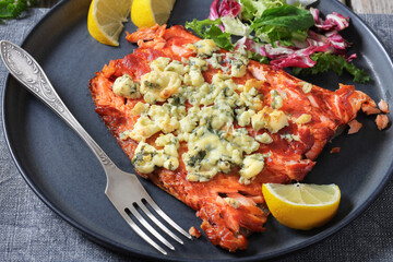 baked salmon topped with blue cheese on a plate